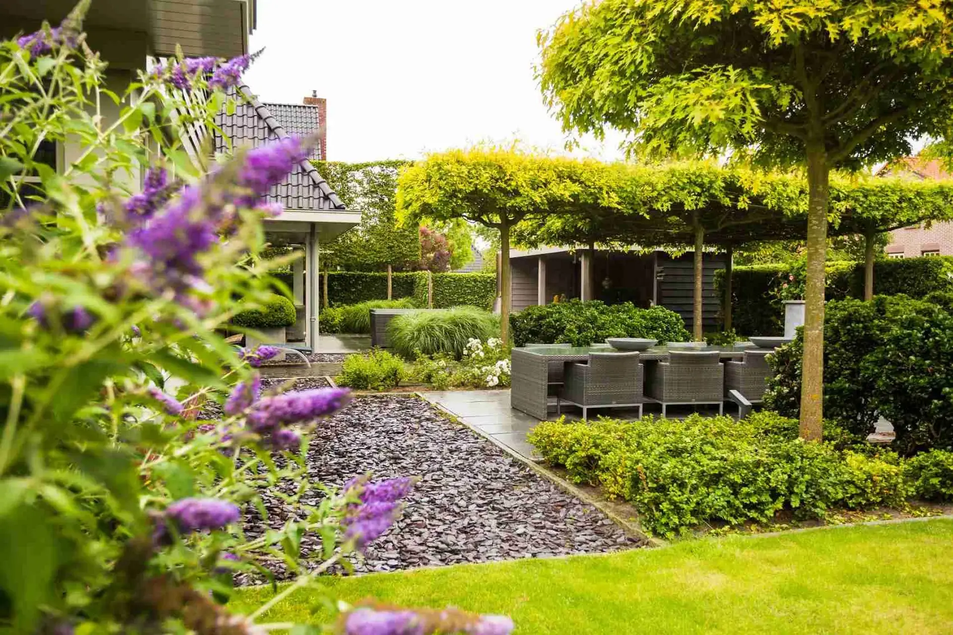 Luxe buitenkamer met pergola en groene tuin, ontworpen door Art Verde